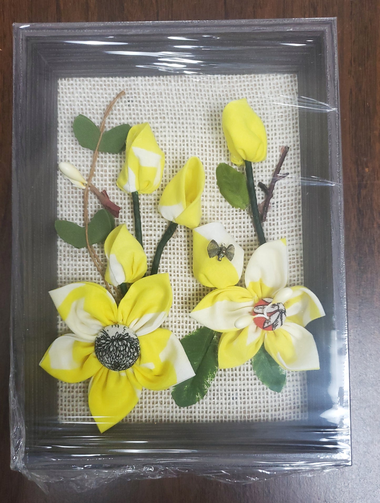 3D Handmade fabric flowers and green leaves, put them in a picture frame, flowers are made of fabric.