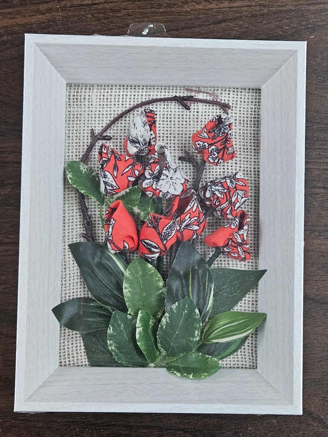 Handmade flowers with Red flower and green leaves, put them in a picture frame, flowers are made of fabric.