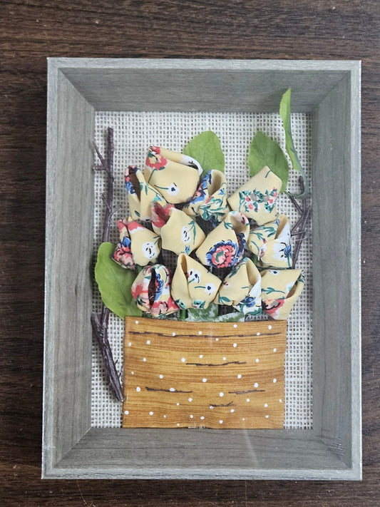 Handmade flowers with yellow flower pots and green leaves, put them in a picture frame, flowers are made of fabric.