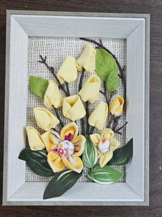 Handmade flowers with Yellow flower and green leaves, put them in a picture frame, flowers are made of fabric.